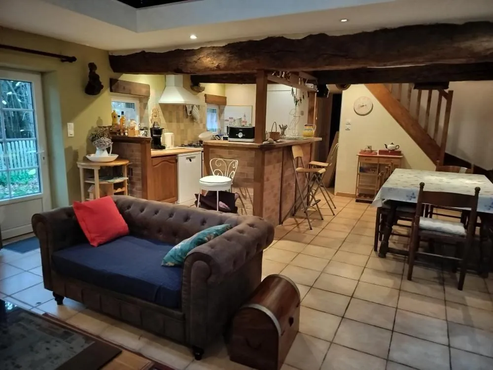 Le séjour du gîte, canapé Chesterfield et poutres apparentes